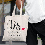 Bolsa Tote Monograma de Casamento Personalizado do Coração El<br><div class="desc">Saco personalizado do Sr. tote para o noivo recém-casado apresenta um elegante roteiro preto moderno e um estilo clássico de sobrenome e um texto monograma de data de casamento que pode ser personalizado. Design inclui um detalhe de coração vermelho fofo. Faz um presente de casamento excelente para a lua de...</div>