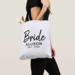 Bolsa Tote Monograma de Data Estabelecida de Preto Branco de<br><div class="desc">Você não pode passar sem este Saco de Tote de Monograma de Data Estabelecida com Preto Branco de Script Bride. Ele é projetado em ambos os lados com "noiva" em letras negras modernas. Personalizado com o nome da noiva e ano de casamento. Ideia de presente de excelente para chá de...</div>