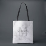 Bolsa Tote Monograma e nome da Bridesmaid Personalizada<br><div class="desc">Adicione um toque pessoal ao seu casamento com o monograma personalizado da dama de honra e o presente de nome. Este design apresenta o nome da dama de honra personalizada com título e data de casamento em cinzas e monograma em cinzas leves como fundo, no estilo clássico de fonte serif,...</div>