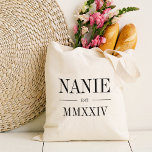 Bolsa Tote Nanie Roman Numeral Year Estabelecido<br><div class="desc">Uma bolsa de tote moderna minimalista para celebrar uma avó cômica,  esta bolsa mínima limpa apresenta "Nanie" ou sua escolha de apelido avó em letras negras de serifa. Personalize com o ano em que ela se tornou avó por baixo de elegantes números romanos para um toque chic.</div>
