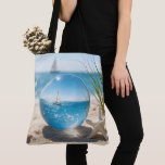 Bolsa Tote Ocean Reflection in a Lens Ball<br><div class="desc">A sailboat on a sunlit ocean,  its reflection captured in a glass lens ball on beach sand next to a starfish</div>