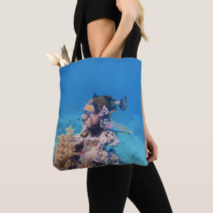 Bolsa Tote Peixe-balão repousa sobre um bloco de coral em um 