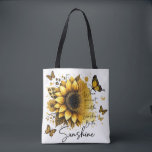 Bolsa Tote Sunshine Be the Sunshine |<br><div class="desc">This tote bag features a clean, modern design with a soft, uplifting aesthetic. The bag itself is white with sturdy black shoulder straps, creating a nice contrast that makes the artwork stand out. The front showcases a large, beautifully detailed sunflower in rich golden and amber tones, with layered petals and...</div>