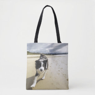 Bolsa Tote Um cão de border collie que funciona na praia