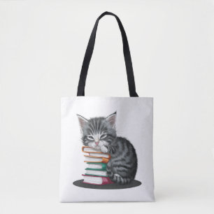 Bolsa Tote Um gatinho sonolento amontoado com uma pilha de li