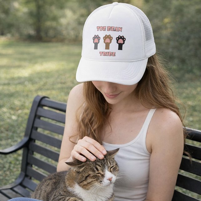 Boné Tribo do Dedo do Pé do Gatinho Divertido Patinhas  (A hat with three cat paws and the words toe bean tribe in pink letters with a gray outline.)