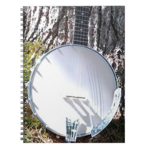 Caderno Espiral Banjo que descansa contra uma árvore