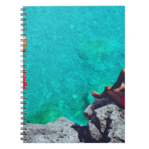Caderno Espiral Homem e mulher sentados em pedra perto do corpo de