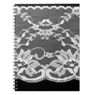 Caderno Espiral Lace floral branco sobre fundo preto.