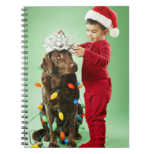 Caderno Espiral Menino novo que envolve luzes de Natal em torno de