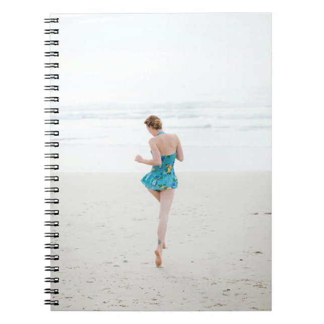 Caderno Espiral Mulher caminhando na praia perto da praia (Frente)