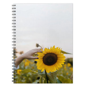 Caderno Espiral Pessoa que segura girassol