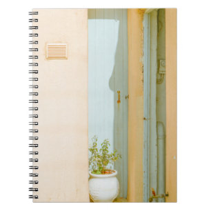 CADERNO ESPIRAL PLANTA VERDE COM VASSO CERÂMICO AO LADO DA MADEIRA