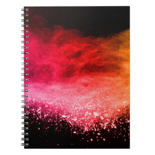 Caderno Espiral Pó colorido lançado, isolado em fundo preto