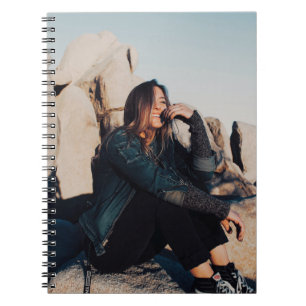 Caderno Espiral Sentada e sorridente vestindo calças pretas