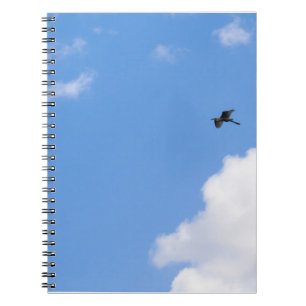 Caderno Espiral Solitary Bird Soaring Through Bright Blue Sky with