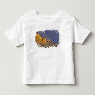 Camiseta Arco-íris duplo sobre uma formação rochosa perto d