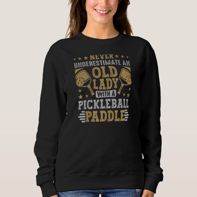 Camiseta As Mulheres Nunca Subestimam Uma Velhinha Com Uma  (Frente)