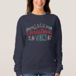 Camiseta Beachy Christmas Vibes Tropical Summer Beach<br><div class="desc">Beachy Christmas Vibes Tropical Summer Holiday Sweatshirts apresenta uma design de Natal divertida com o texto "Beachy Christmas Vibes" na tipografia moderna,  destacada por conchas,  palmeiras e presentes. Perfeito para um verão ou um Natal tropical e feriados. Criado por feriados Evco www.zazzle.com/store/evcoholidays</div>