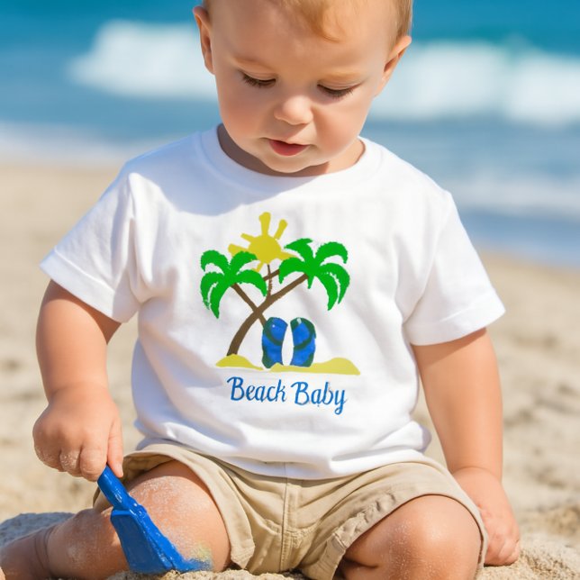Camiseta Bebê Fofo da Praia  (a toddler playing in the sand with a small blue shovel, wearing a white crewneck short-sleeve tee-)
