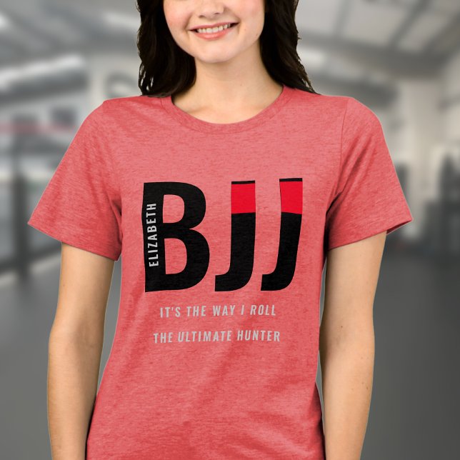Camiseta BJJ brasileira Jiu Jitsu adiciona nome de mulher (Red BJJ woman's Tshirt worn by a female model in a gym.)