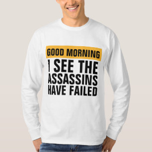 CAMISETA BOA MANHÃ EU VEJO QUE ASSASSINOS FALHARAM EM T-SHI