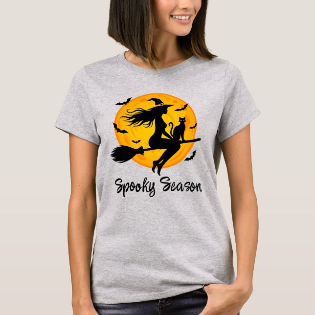 Camiseta Bruxa e Gato Preto Voando Através da Lua Cheia (Frente)