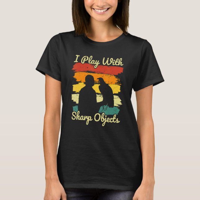 Camiseta Caça à Falcão Eu Brinco Com Objetos Afiados Para F (Frente)