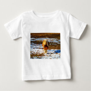Camiseta Cavalo marrom e minúsculo creme na neve.