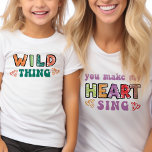 Camiseta Coisa Selvagem Você Faz Meu Coração Cantar Maçal C<br><div class="desc">Camiseta infantil "selvagem" com a versão de t-shirt da mãe 'você faz meu coração cantar' disponível. Este design de tipografia colorido apresenta a curvatura de retrorreflectores modernos e impressão de esboço em cores brilhantes, decorado com corações amorosos. Citação engraçada, dividida entre a mãe e o equipamento infantil que também funciona...</div>