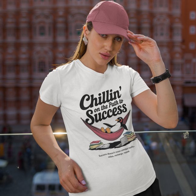 Camiseta Consertando no caminho para uma inspiração de suce (woman wearing white graphic t-shirt with a penguin resting in a hammock featuring typography on top)