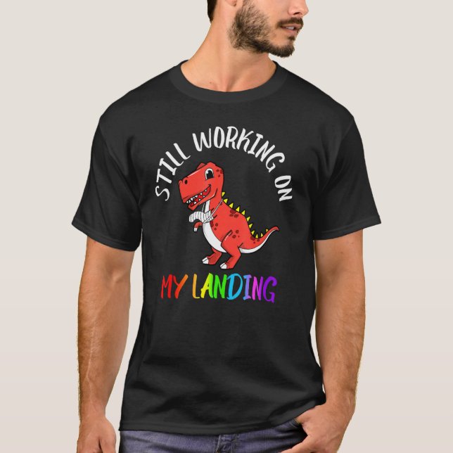 Camiseta Continuando Trabalhando Em Minha Aterrissagem Feri (Frente)