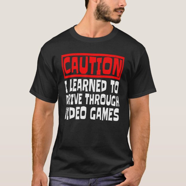 Camiseta Cuidado eu aprendi a dirigir através de jogos de v (Frente)