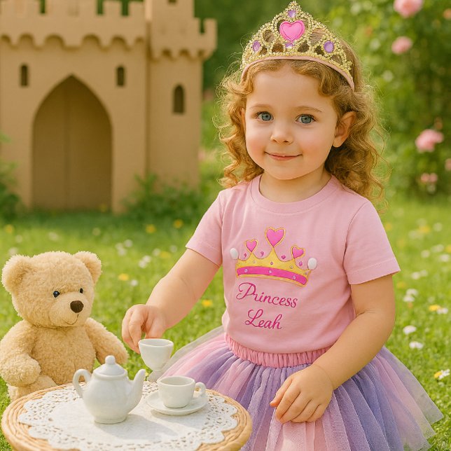 Camiseta de Bebê Menina Princesa Rosa Fofa (A joyful toddler girl at a tea party with a teddy bear. This t-shirt is ideal for a little princess)