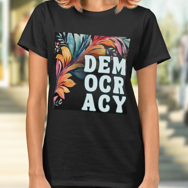 Camiseta Declaração Colorida Groovy da Democracia (A t-shirt with 'Democracy' in capital letters in a retro groovy style, on a colorful leafy backdrop)