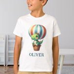 Camiseta Dino Verde Fofo Voa em um Balão de Ar Quente<br><div class="desc">Deixe a imaginação do seu pequeno explorador voar com esta camiseta personalizada que apresenta um dinossauro encantador em uma aventura épica! Imagine um vibrante balão de ar quente que desperta sonhos infinitos de descoberta. Esta camiseta confortável e elegante é mais do que apenas uma roupa - é um passaporte personalizado...</div>