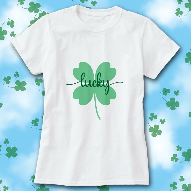 Camiseta do Dia de São Patrício com Letra de Trevo (White t-shirt with green Lucky script on a large solid green four-leaf clover graphic.)