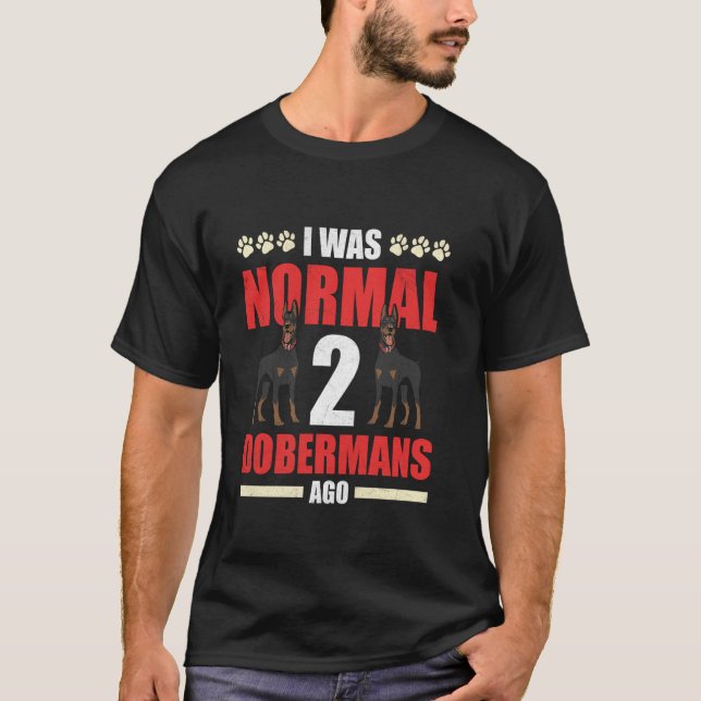 Camiseta Dono de Doberman ERA NORMAL 2 DOBERMANS ATRÁS Engr (Frente)