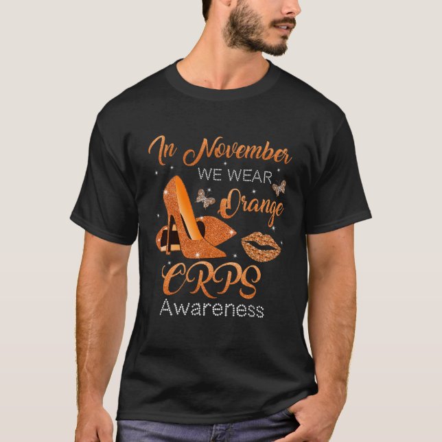 Camiseta Em novembro, Vestimos Calçados de Altos Cores Lara (Frente)