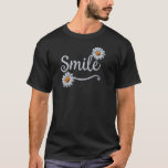 Camiseta Embroidered Daisy Smile – Floral Cursive Typograph<br><div class="desc">Spread joy with this beautiful, embroidery-inspired design. The word "Smile" is written in a delicate, textured white cursive script that mimics the look of high-quality hand-stitching. The design is accented by two detailed daisy flowers with crisp white petals and vibrant, golden-yellow textured centers. One daisy playfully dots the "i, "...</div>
