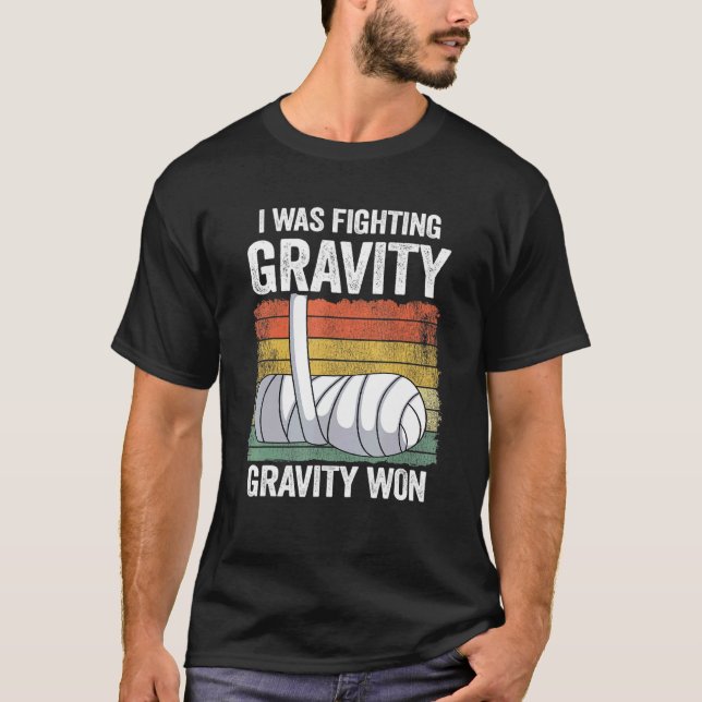Camiseta Eu Estava Lutando Com Gravidade Ganhei Mão Quebrad (Frente)