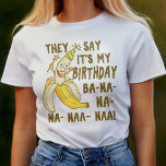 Camiseta Funny Birthday Cartoon Banana Humor Único<br><div class="desc">Dizem que é o meu aniversário / Ba-na-na-na-naa-naa! Esta camiseta engraçada de aniversário de bobo tem uma banana desenhada à mão segurando uma varinha estelar e vestindo um chapéu de aniversário pontiagudo. É adequado para todas as idades: crianças e crianças eternas. Celebre seu aniversário em estilo com esta camisa ridícula....</div>