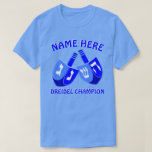 Camiseta Hanukkah Dreidels no campeão bonito azul de<br><div class="desc">Adicione um nome a esta camiseta engraçada de Hanukkah do campeão de Dreidel para um presente personalizado ou como pouco deleite para o senhor mesmo. O design gráfico corajoso dos dois Dreidels em máscaras brilhantes de azul e do branco inclui um modelo para seu nome acima com de "o campeão...</div>