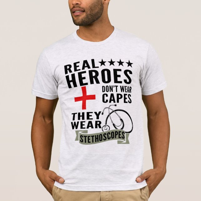 Camiseta Heróis Reais Não Vestem Capas Vestem Estetoscópios (Frente)
