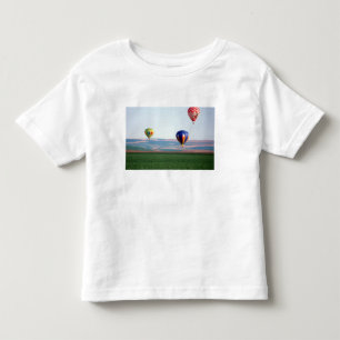 Camiseta Infantil Balões de ar quente coloridos flutuam sobre o tri