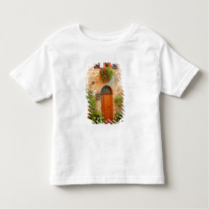 Camiseta Infantil Um gato procura entrada em casa em Pienza, Itália.