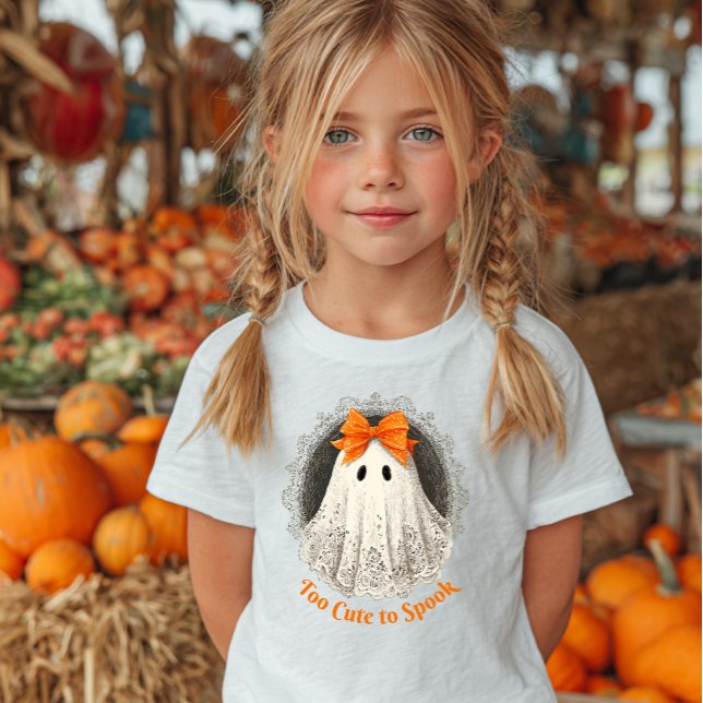 Camiseta Lace Ghost in Orange Bow Ornate Frame Design (Girl wearing a white shirt with a cute ghost illustration and "Too Cute to Spook.)