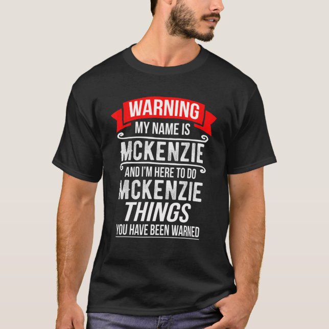 Camiseta Meu nome é Mckenzie e estou aqui para fazer Mckenz (Frente)