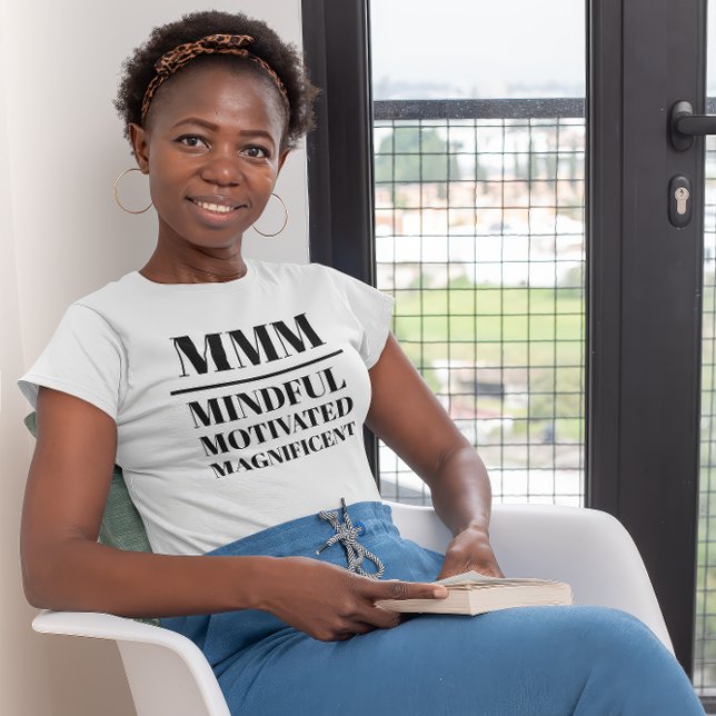 Camiseta MMM- Mindful, Motivated, Magnífico (Young black woman wearing a "MMM:Mindful, Motivated, Magnificient" white t-shirt.)