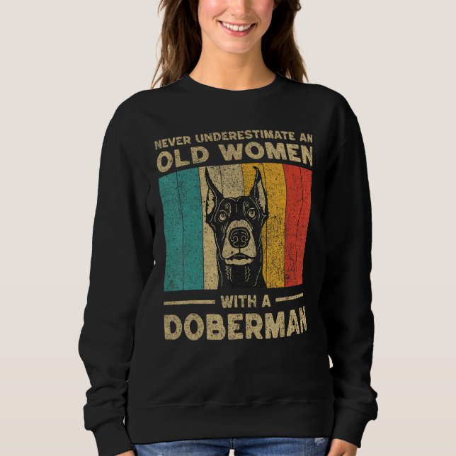 Camiseta Never Underestimate An Old Women With A Doberman P (Frente)